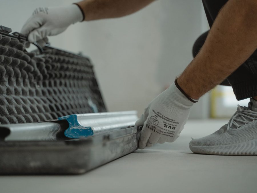 Handwerker glättet mit Werkzeug einen frisch verlegten Untergrund